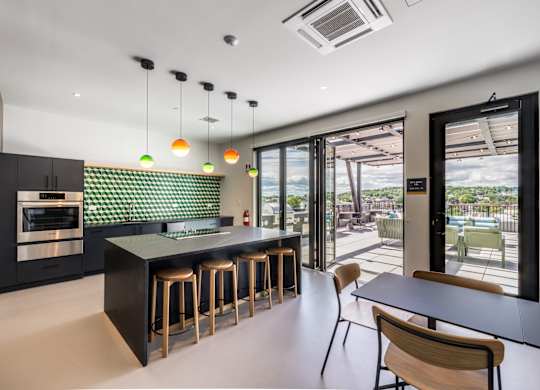 A modern kitchen with a bar area and a view of the outdoors.