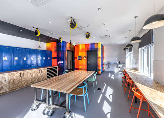 A room with a long table and chairs on wheels.