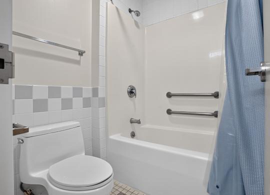 A white toilet sits next to a bathtub in a bathroom.
