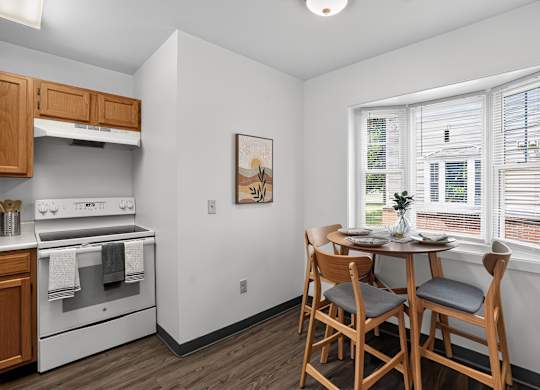 A kitchen with a dining table and chairs.