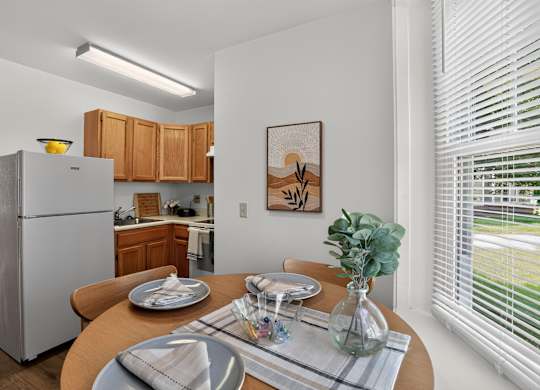 A modern kitchen with a dining table set for two.