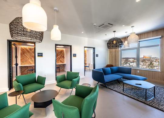 A living room with green chairs and a blue sofa.