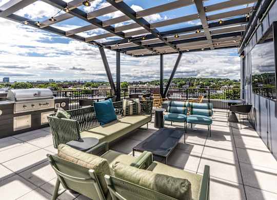 A patio with a table and chairs overlooking a cityscape.