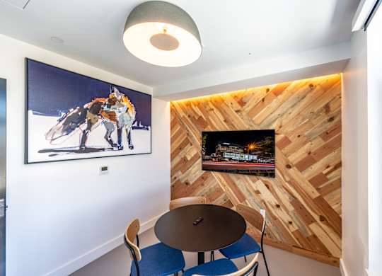 A room with a wooden wall and a picture of a horse on the wall.