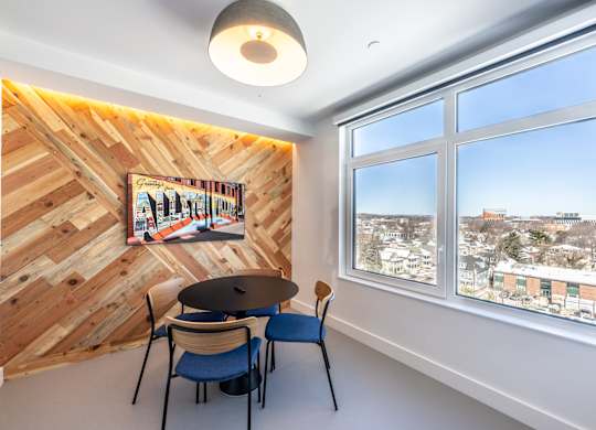 A room with a wooden wall and a table with chairs.