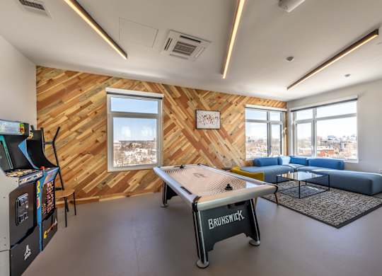 A room with a wooden wall and a pool table.