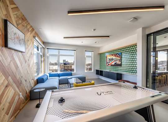 A room with a shuffleboard table in the middle.
