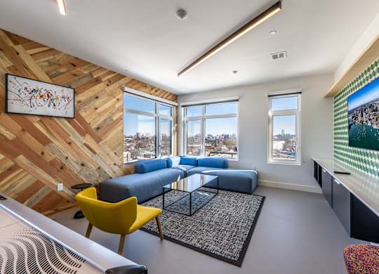 A living room with a yellow chair and a blue couch.