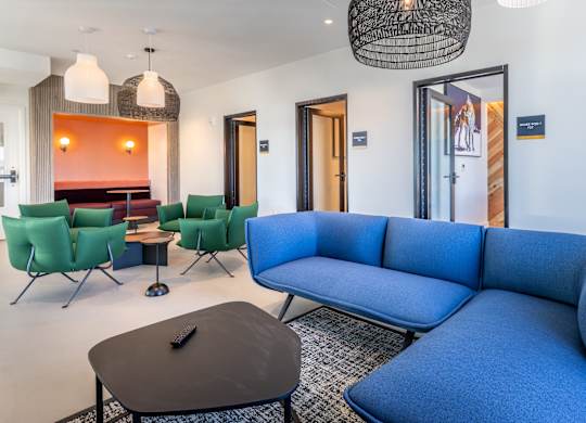 A blue couch is in the middle of a room with a black table in front of it.