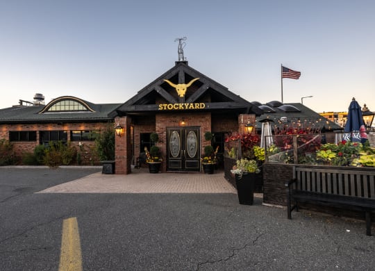 the facade of The Stockyard  restaurant with a flag at dusk
