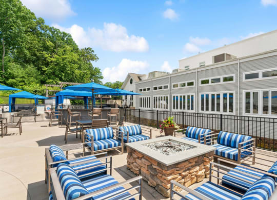 a patio with blue and white chairs and tables and a fire pit at The Tannery, Connecticut, 06033
