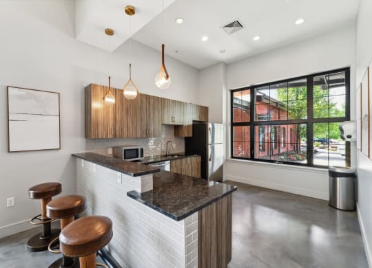 a kitchen with a bar and stools in front of a large window in the clubhouse at The Tannery, Connecticut