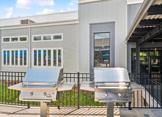 two bbq pits outside of a restaurant with a building in the background at The Tannery, Glastonbury