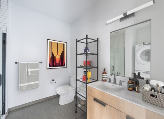 a bathroom with a toilet sink and a shower and a washing machine