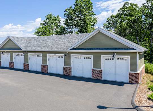 A building with a grey roof and white garage doors.