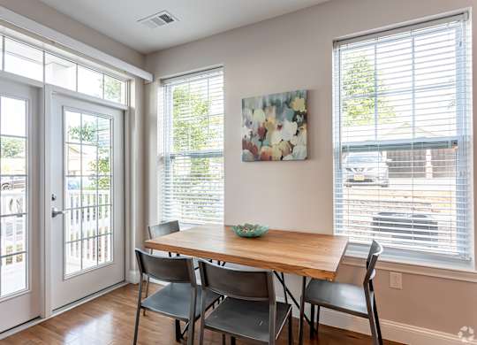 A dining room with a table and chairs.