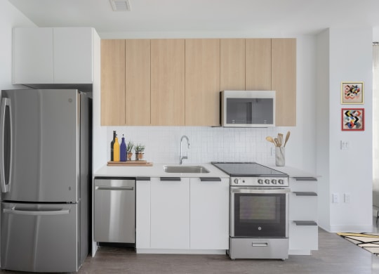 a kitchen with white cabinets and stainless steel appliances