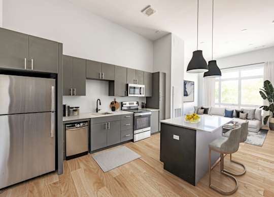 a kitchen with stainless steel appliances and a large island with a breakfast bar at Seacoast Residences Apartments, Oakland, ME
