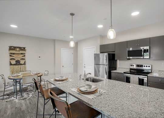 A modern kitchen with granite countertops and stainless steel appliances.