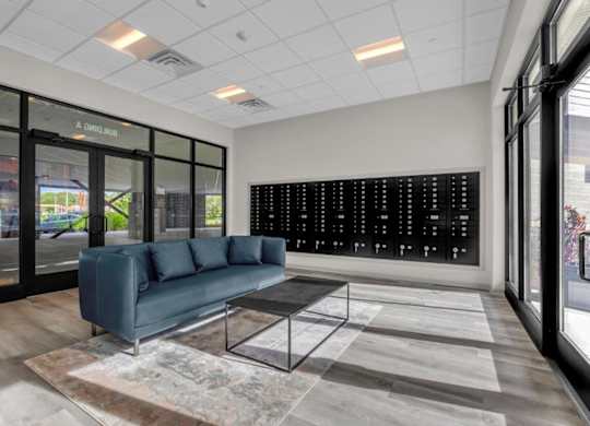 a lobby with a blue couch and a glass coffee table