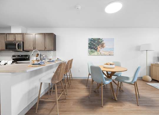 A kitchen with a dining table and chairs.
