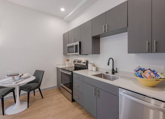 A modern kitchen with a table and chairs at Seacoast Residences Apartments, Maine