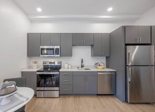 A modern kitchen with stainless steel appliances and wooden flooring at Seacoast Residences Apartments, Oakland, ME, 03904