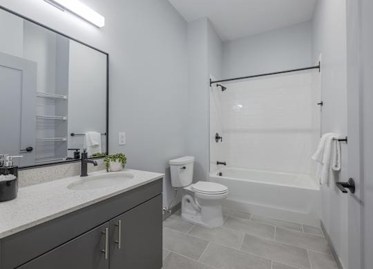 A bathroom with a white toilet, sink, and bathtub. at Seacoast Residences Apartments, Oakland, ME, 03904