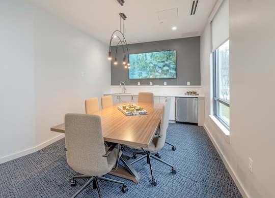 A conference room with a table, chairs, and a TV on the wall at Seacoast Residences Apartments, Oakland, ME, 03904
