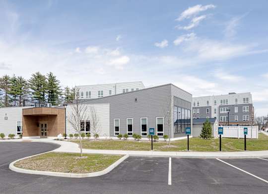 A modern building with a parking lot in front at Seacoast Residences Apartments, Oakland, Maine