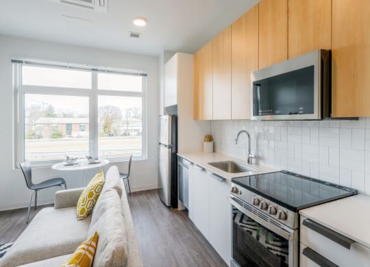 a living room with a couch and a kitchen with a sink