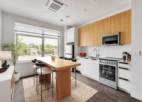A modern kitchen with white appliances and wooden cabinets.