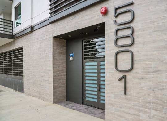 a view of the entrance to the building with the number 5690 on the side at The Fairfax Flats Apartments, Los Angeles, CA