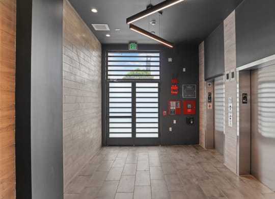 a view of a hallway with a door at the end of the hallway at The Fairfax Flats Apartments, Los Angeles, CA, 90019