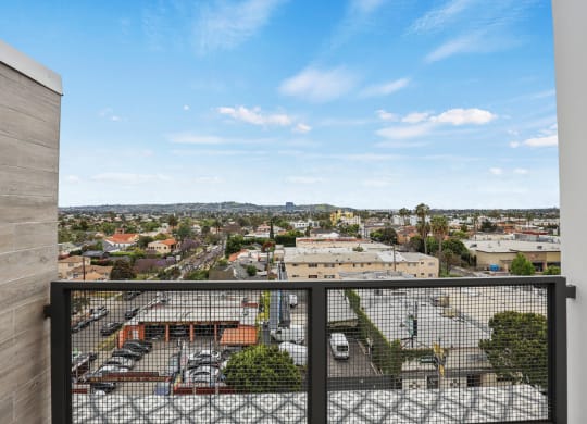 a balcony with a black railing and a view of a city at The Fairfax Flats Apartments, Los Angeles, CA