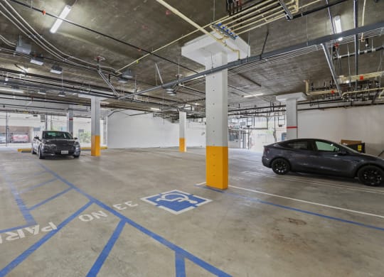 a parking garage with two cars in it at The Fairfax Flats Apartments, Los Angeles, California
