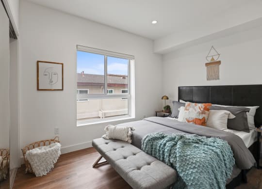 a bedroom with a large bed and a large window at The Fairfax Flats Apartments, Los Angeles, CA