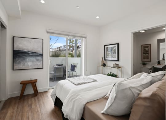 a bedroom with a bed and a door leading to a balcony at The Fairfax Flats Apartments, Los Angeles, CA, 90019