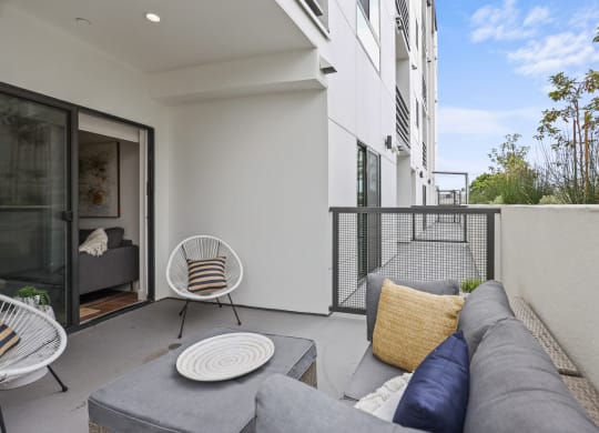 two chairs and a couch on a balcony in a 555 waverly unit at The Fairfax Flats Apartments, Los Angeles, CA