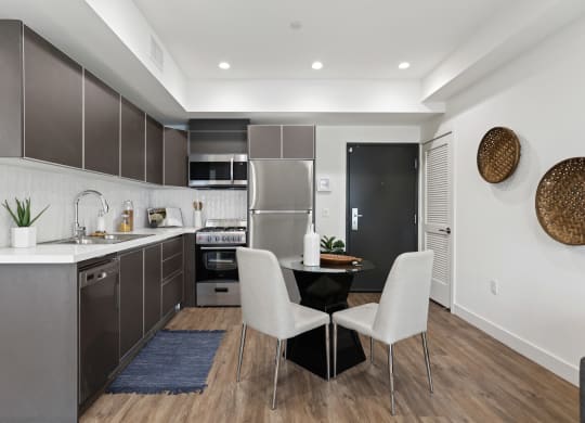 a kitchen with dark cabinetry and white countertops at The Fairfax Flats Apartments, Los Angeles, CA