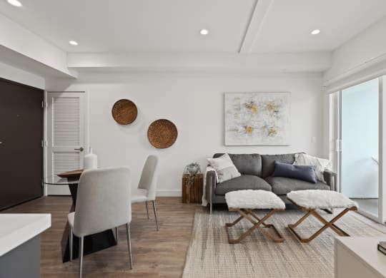 a living room with white walls and a gray couch at The Fairfax Flats Apartments, California