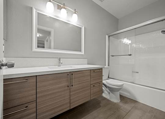 A modern bathroom with a white sink and a large mirror at Lafayette Apartments, Los Angeles