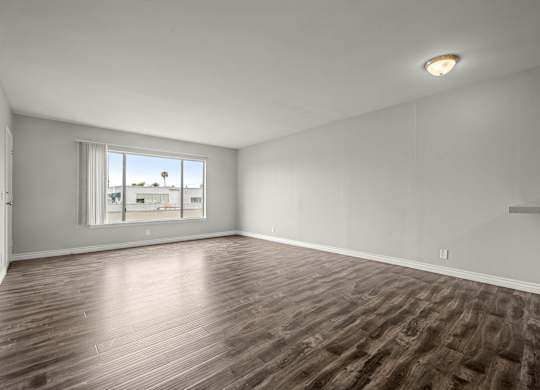 Empty room with wooden flooring and a window at Lafayette Apartments, California