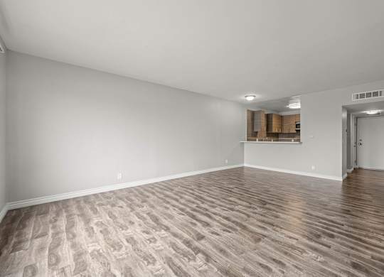 A room with wooden flooring and white walls at Lafayette Apartments, Los Angeles, California
