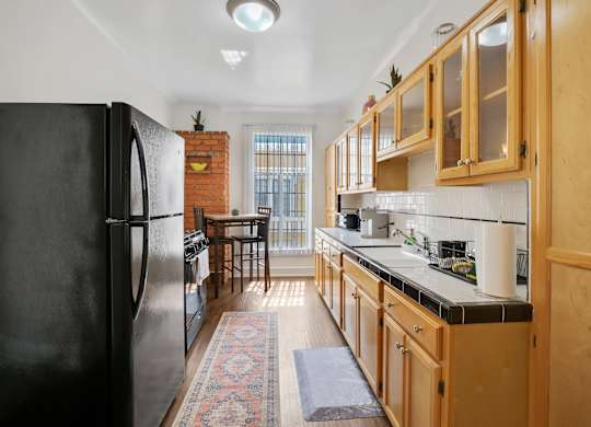 Kitchen with wooden cabinets at The Langham Apartments, Los Angeles, CA