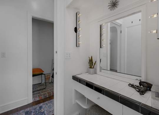 Bathroom with a white vanity and a mirror at The Langham Apartments, Los Angeles, 90005