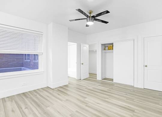 A room with a ceiling fan and wooden flooring.at Park Wilshire, Los Angeles