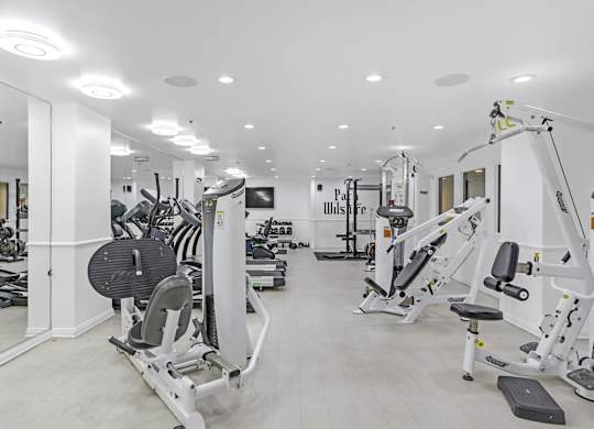 A gym with a variety of equipment including treadmills, weights, and exercise machines.at Park Wilshire, Los Angeles, CA 90057