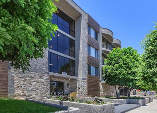 A modern building with a stone facade and large windows at Lafayette Apartments, Los Angeles