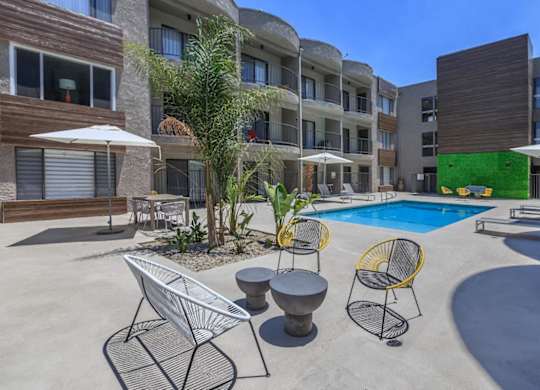 A pool area with a white chair and a yellow chair at Lafayette Apartments, California, 90019